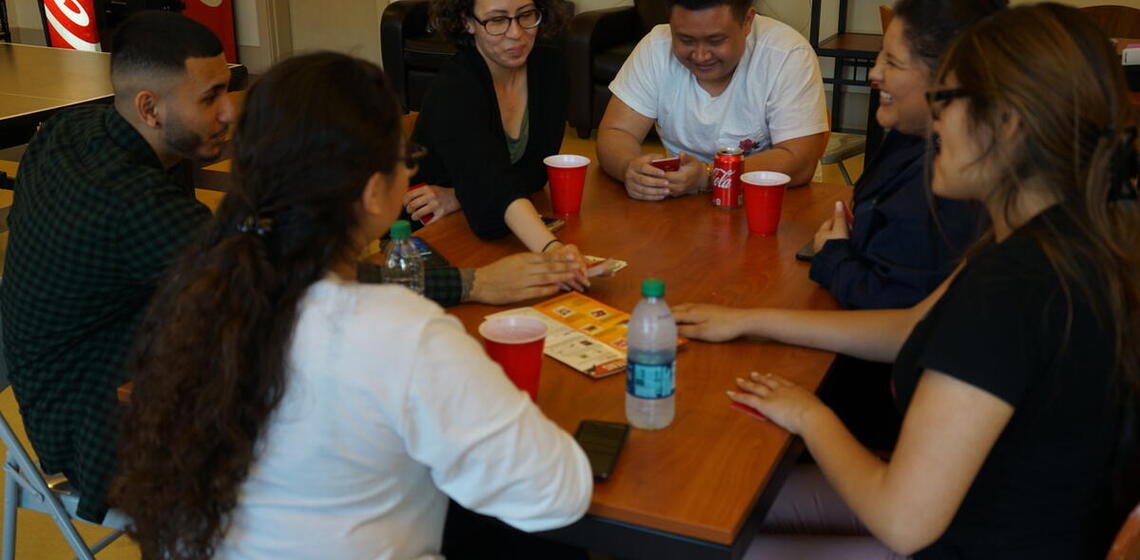Scholars sitting round a table playing games