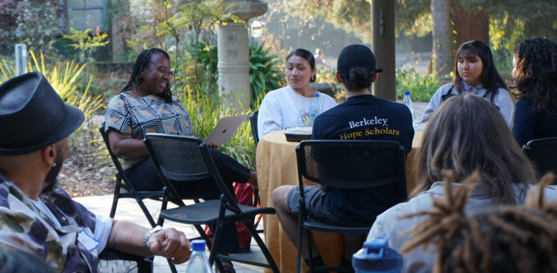 Photo of scholars seated in chairs outside